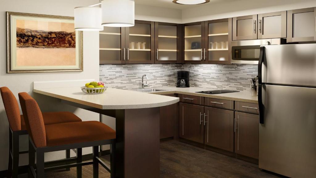 Staybridge Suites Denver Downtown by IHG kitchen with table and red chairs